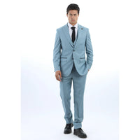 Mies, jolla on vaaleansininen puku, valkoinen paita ja musta solmio valkoisella taustalla